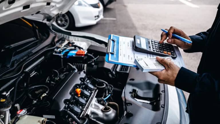 Mechanic calculates the cost of car repairs to customer at garage workshop, Car auto services and maintenance check concept 2186642305