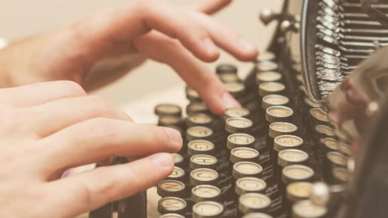 Person typing on typewriter