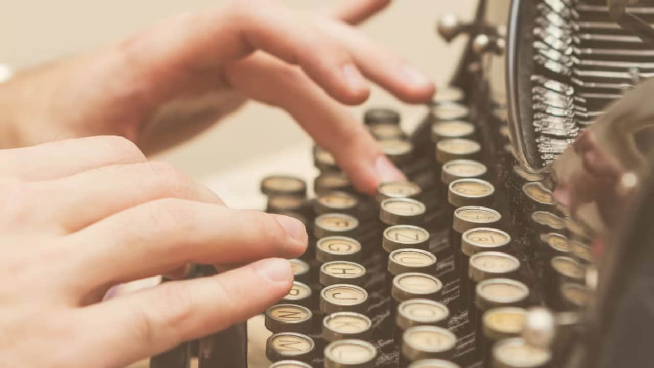 Person typing on typewriter