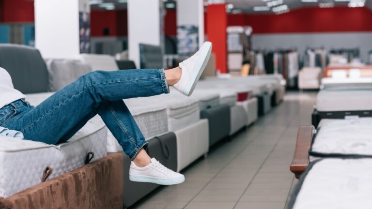 Woman sitting on mattress at a store