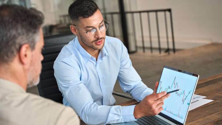 A man points to a screen showing a peak in a line graph with variability