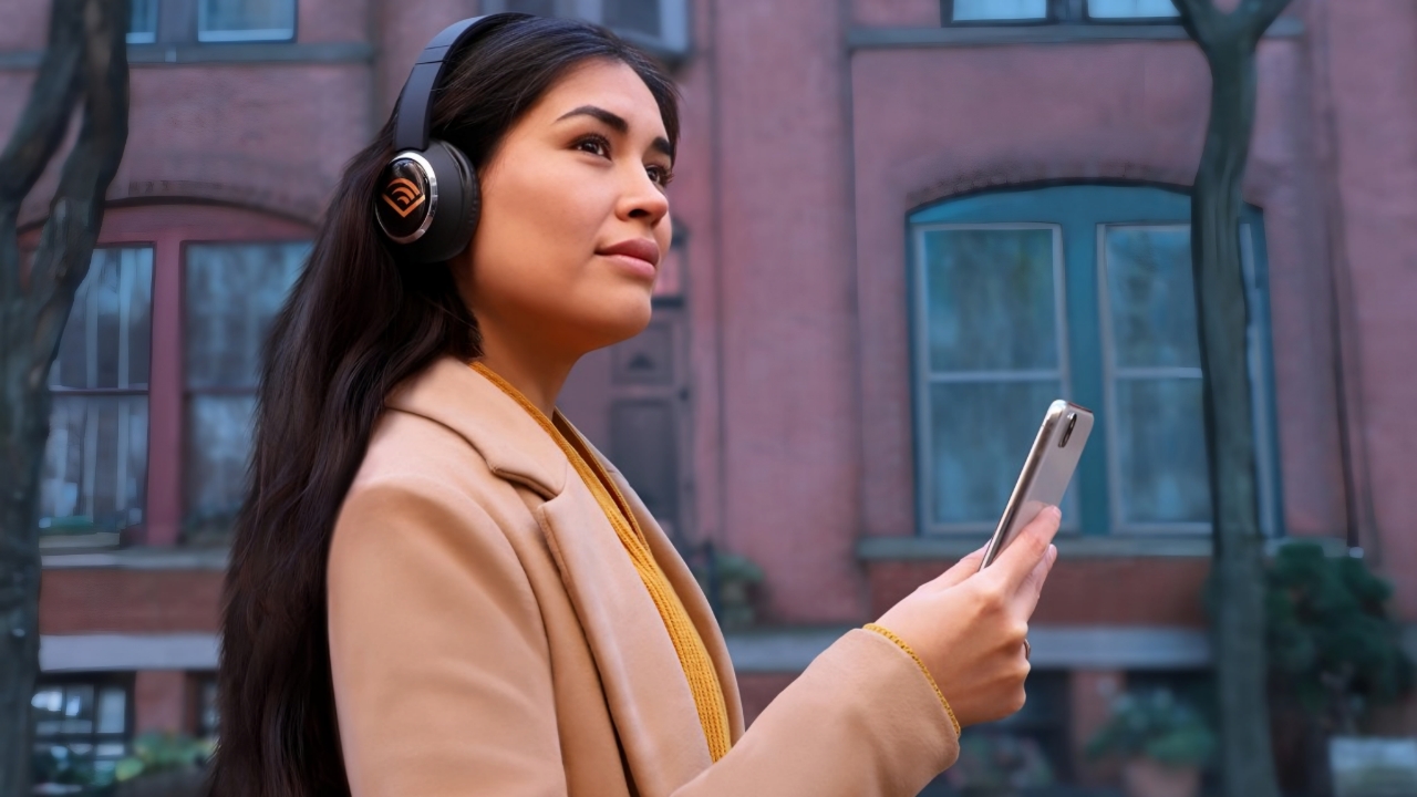 Woman wearing headphones with audible logo on side