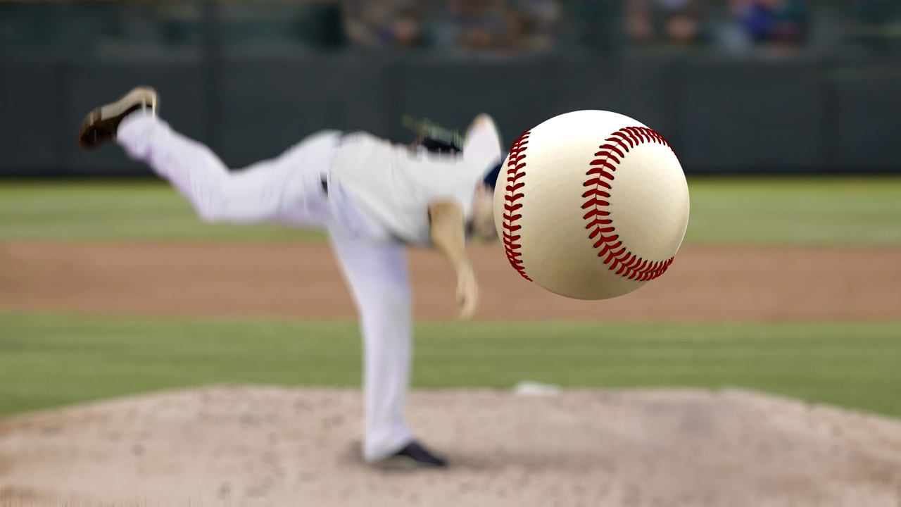 Baseball pitcher throwing fast ball to batter in a stadium