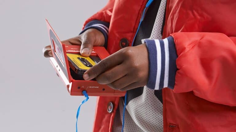 Hands placing a cassette tape in a Walkman