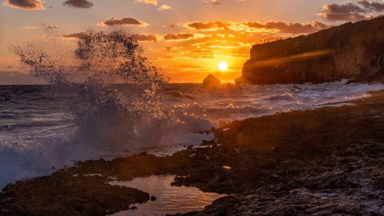 The sun rises over Little Cayman Brac off the limestone bluffs on the East End of Cayman Brac, Cayman Islands.
