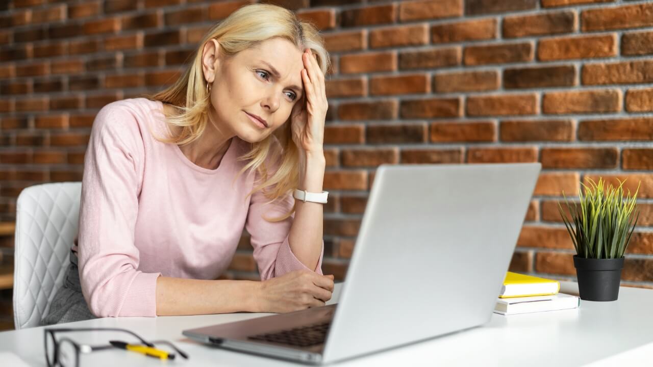 Discouraged woman looking at laptop, upset, sad,