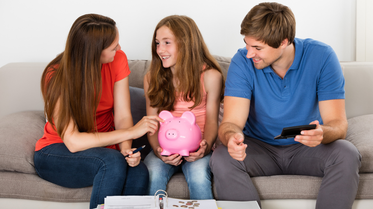 A happy family talking together with child holding a piggy bank