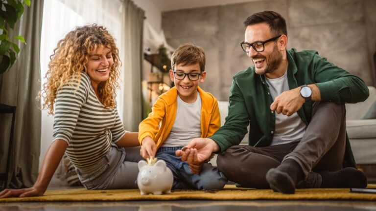 Woman, man, child, boy putting change, money into piggy bank, saving, save