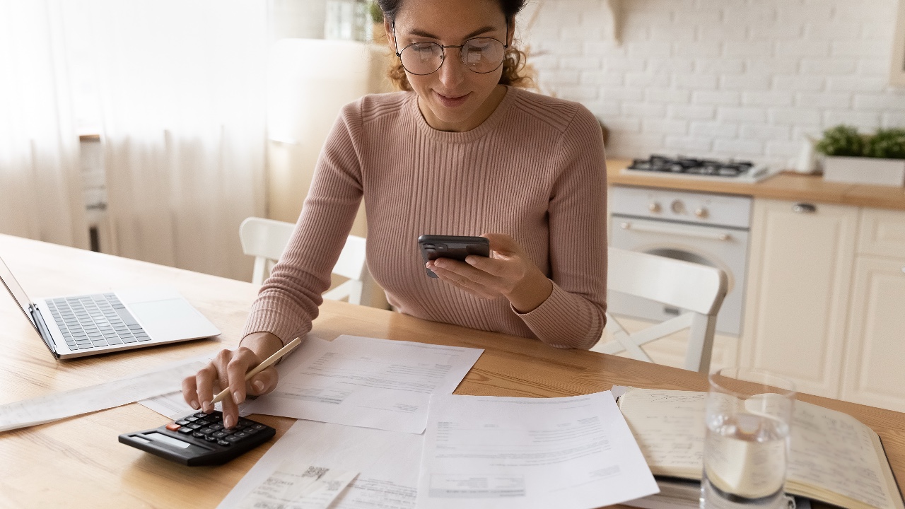 Woman checking utility bills sums to pay