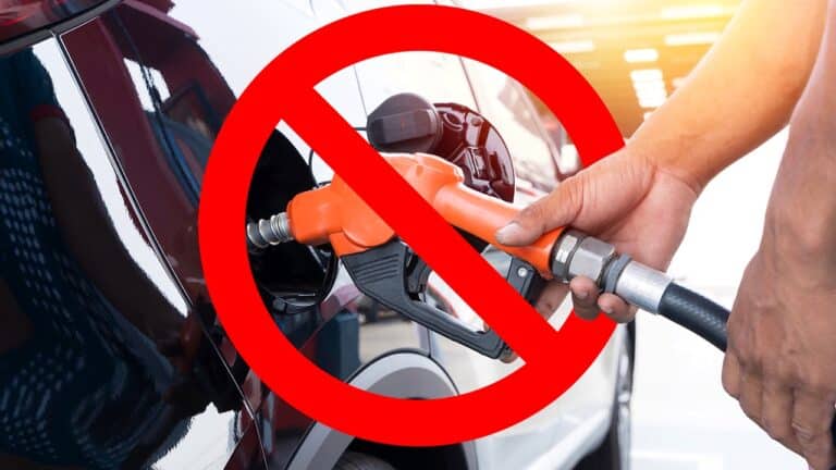Man driver hand refilling and pumping gasoline oil the car with fuel with a banned symbol over the gas nozzle