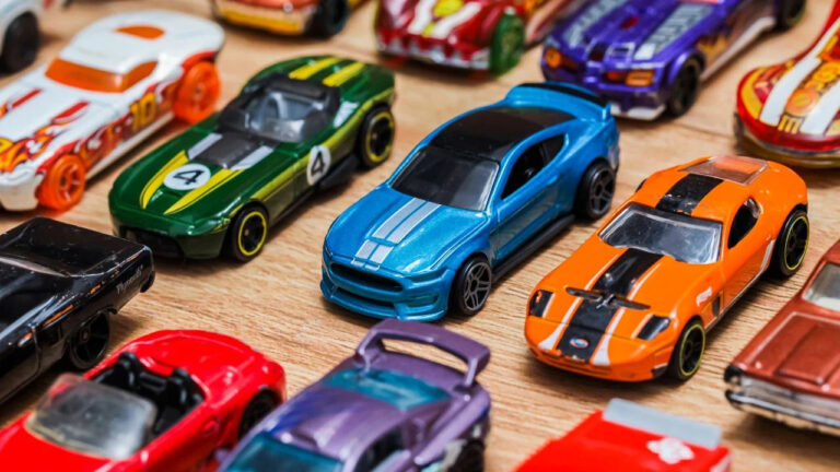 A group of colorful toy car collection on wooden background. Hot Wheels. Top view. Selective focus.