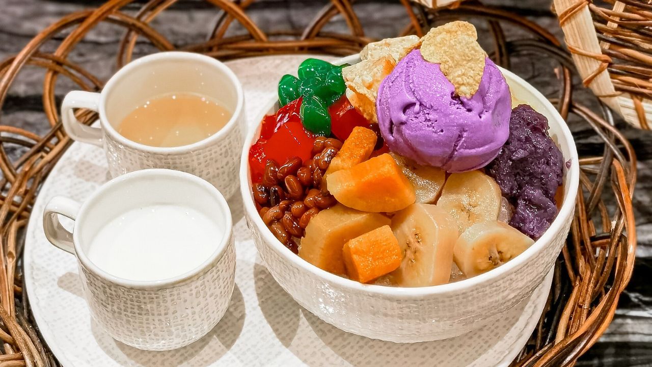 Halo-Halo in a serving tray and bowl, paired with tea. Halo-halo is often served in tall glasses or bowls, allowing the vibrant layers of ingredients to be seen. Halo-halo is a popular and colorful Filipino dessert that translates to "mix-mix" in English. It's a layered dessert that combines a variety of ingredients resulting in a delightful mix of flavors and textures.