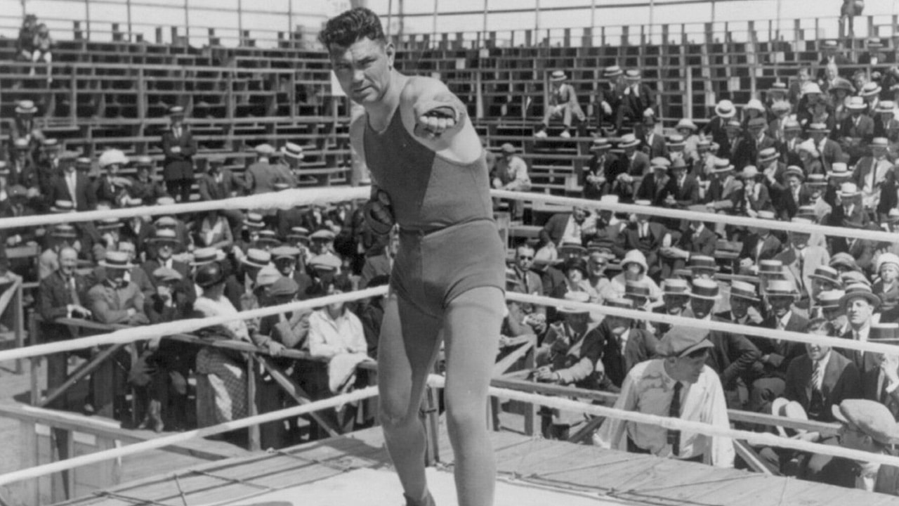 Jack Dempsey at his training camp, June 1921- shadow-boxing in ring; spectators in background