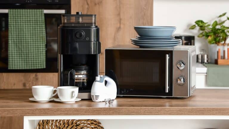 A modern kitchen, with small kitchen appliances resting on the middle island.