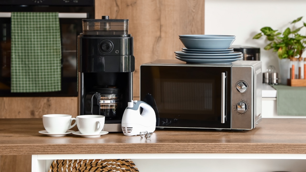 A modern kitchen, with small kitchen appliances resting on the middle island.