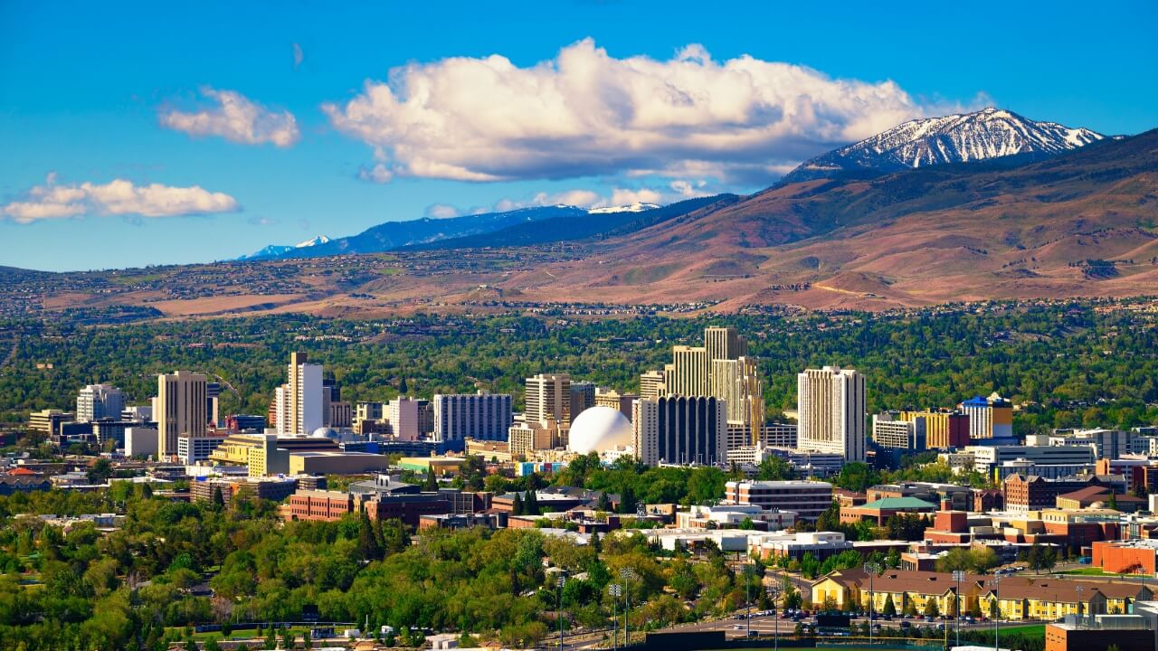 Downtown Reno skyline, Nevada, with hotels, casinos and the surrounding High Eastern Sierra foothills