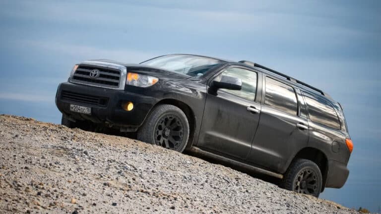 Black offroad SUV Toyota Sequoia in the sand desert.
