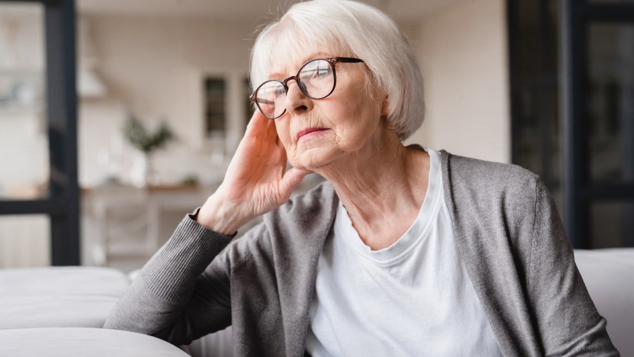 Senior woman staring out window deep in thought