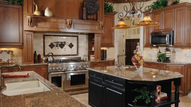 An early 2000's tuscan-inspired kitchen, complete with tan granite countertops, cabinetry, backsplash and kitchen island.