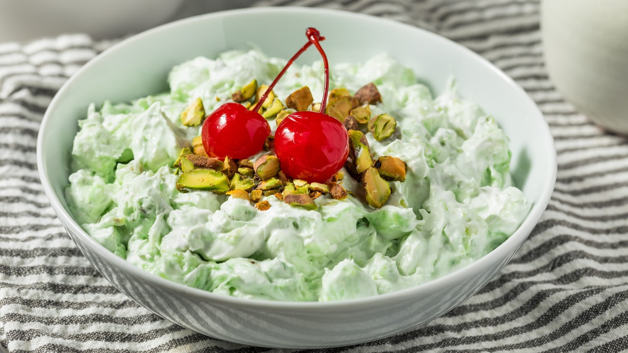 Fluffy, green Watergate salad aka pistachio delight with cherry and pistachio topping