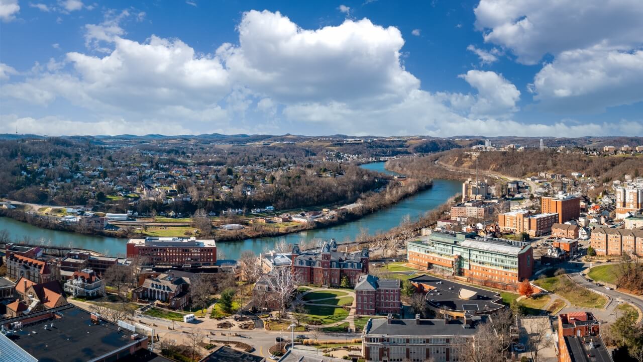 Aerial drone panoramic shot of the downtown campus of WVU in Morgantown West Virginia showing the river in the distance