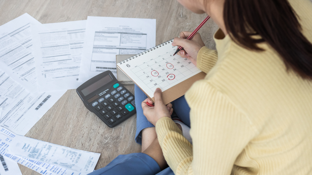 Woman paying bills on time with a calendar