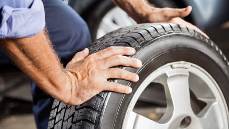 close up of mechanic holding tire