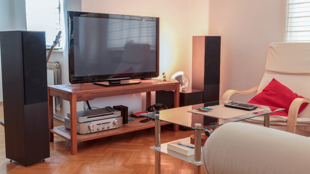 An entertainment center complete with large stereo and speakers, electronic consoles, telephone, and large screen television. 