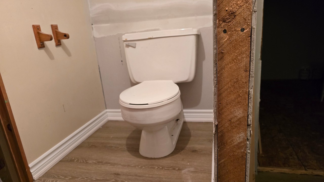 A toilet on a new platform after a bathroom in a basement is being repaired after a flood.