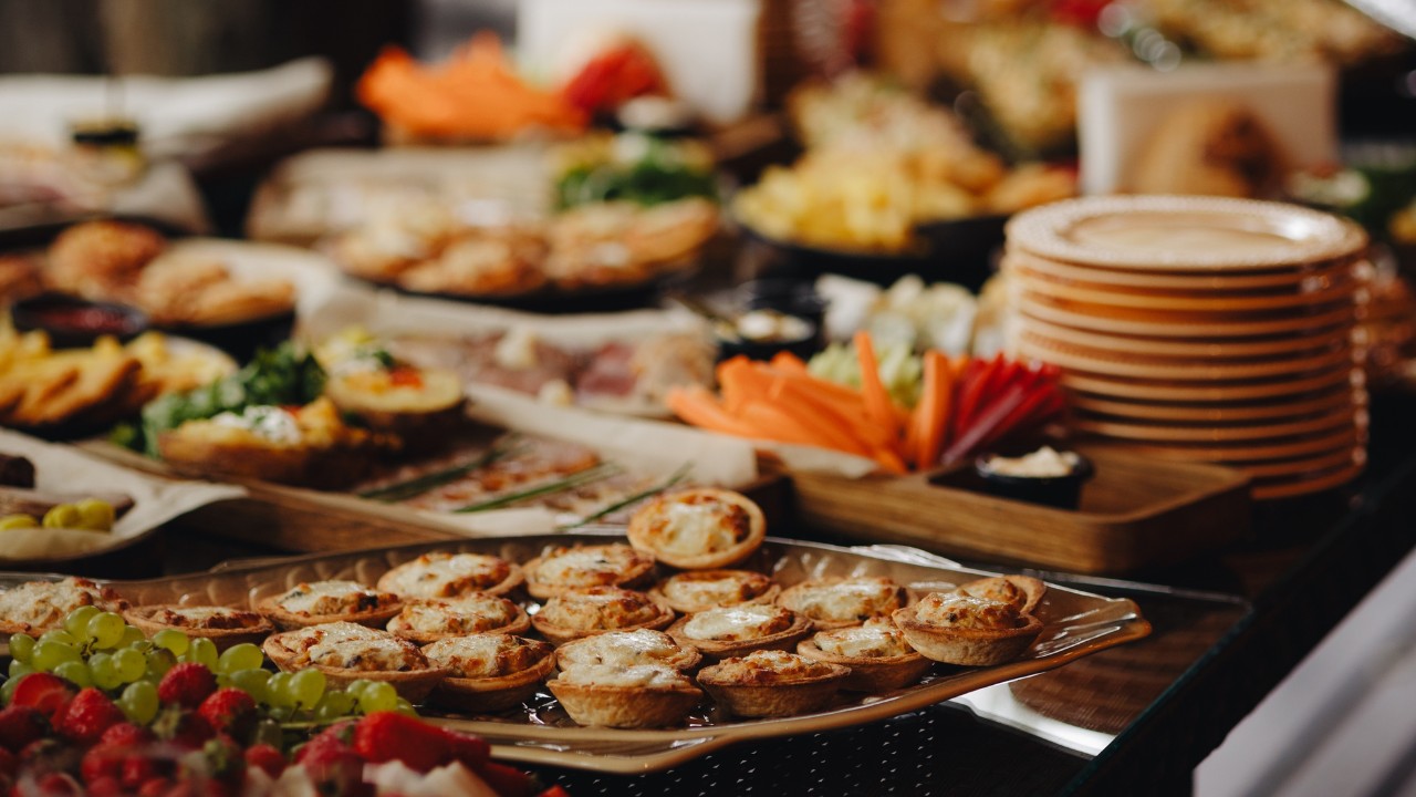 Beautifully decorated catering banquet table with different food snacks and appetizers.