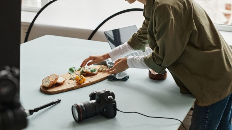 Cropped shot of female food photographer setting up gourmet bruschetta with props in studio, copy space