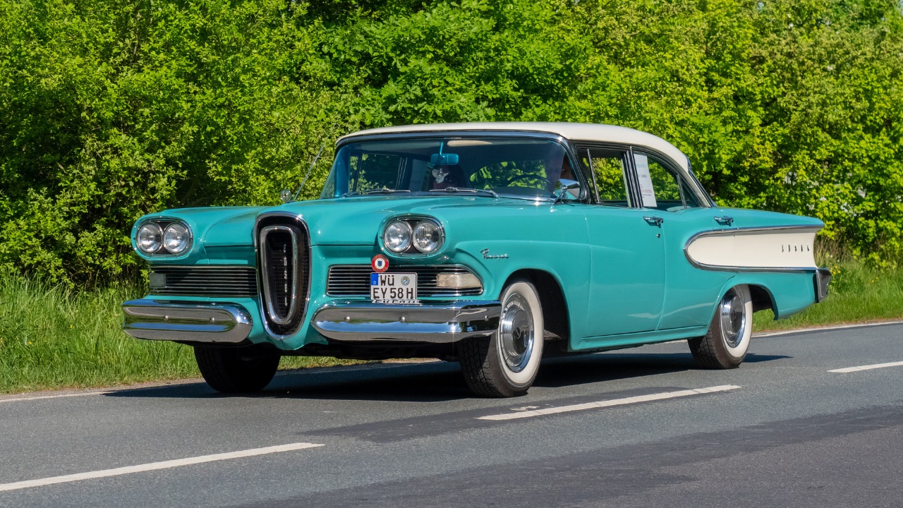 Front-side view of a turquoise Edsel Ranger Sedan driving down the roadway.
