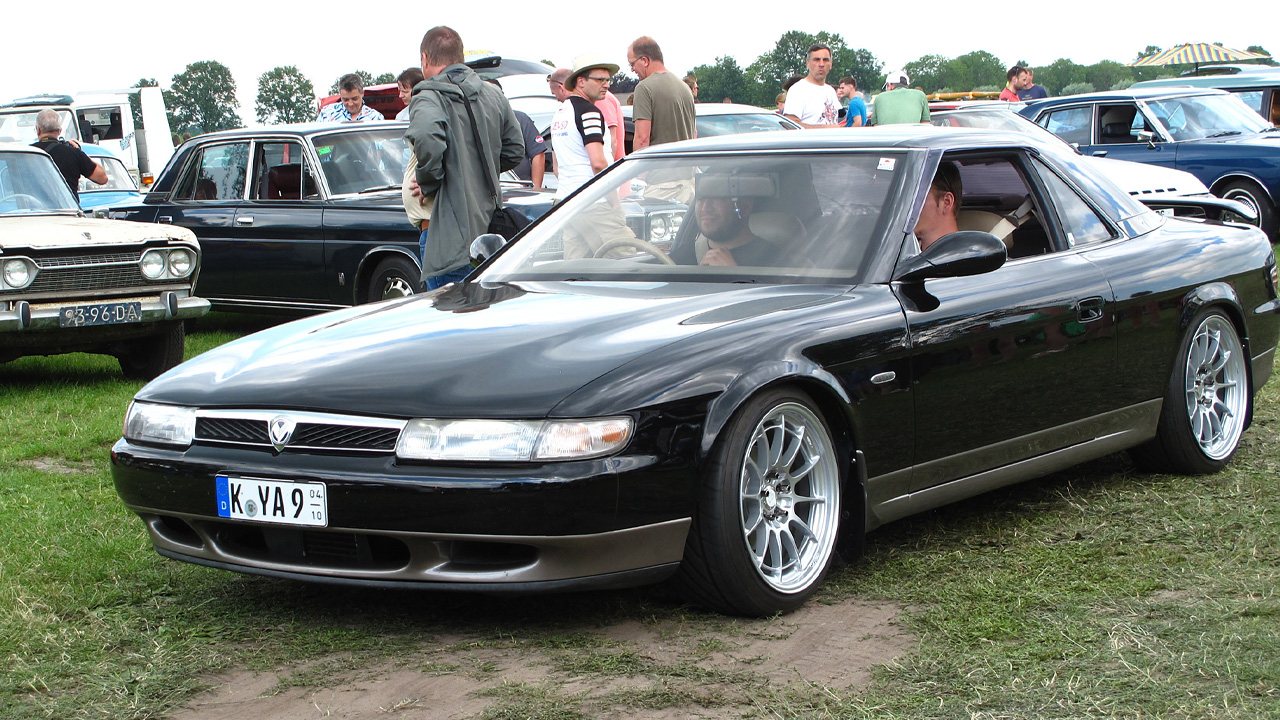 Eunos Cosmo, front 3/4 view, aftermarket wheels, black exterior, car show