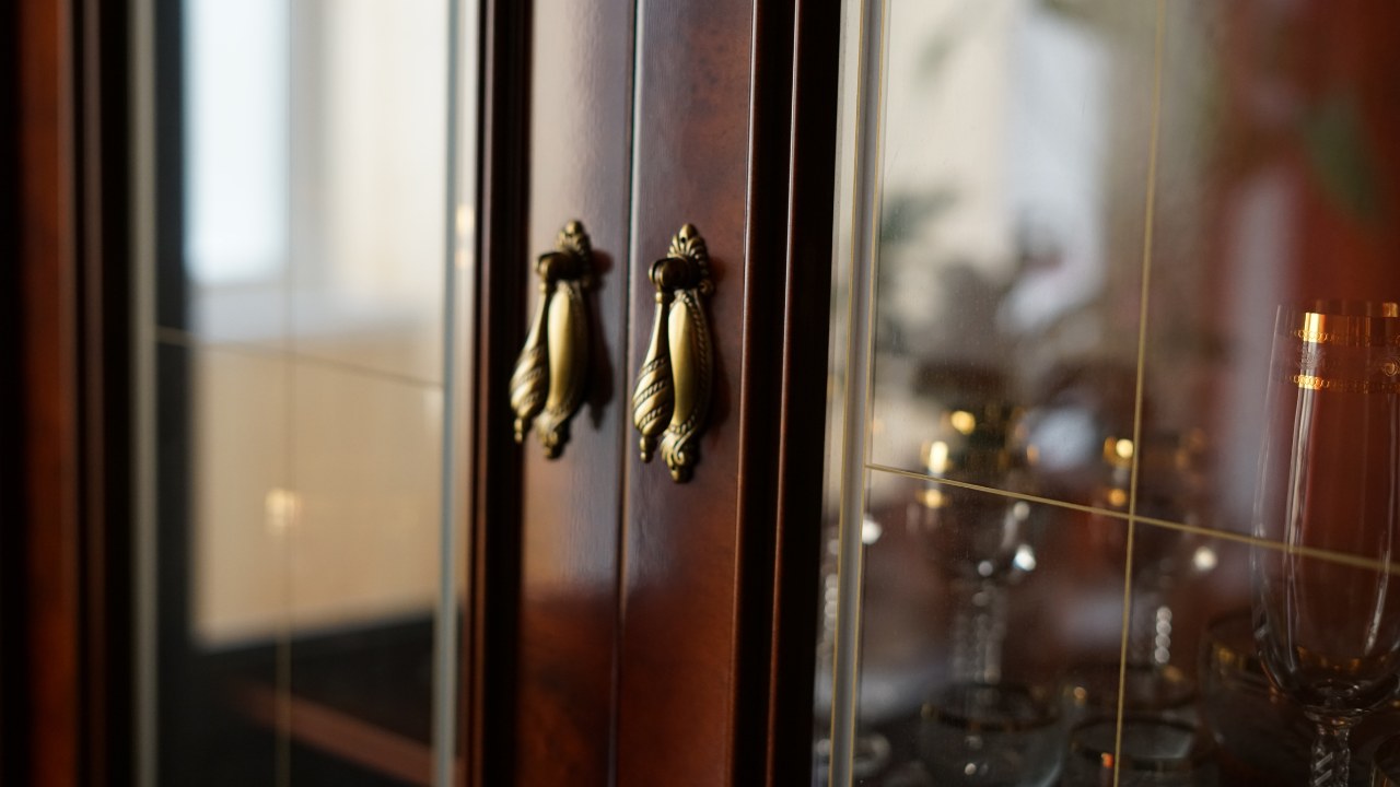 Glass holiday tableware in a liquor cabinet.