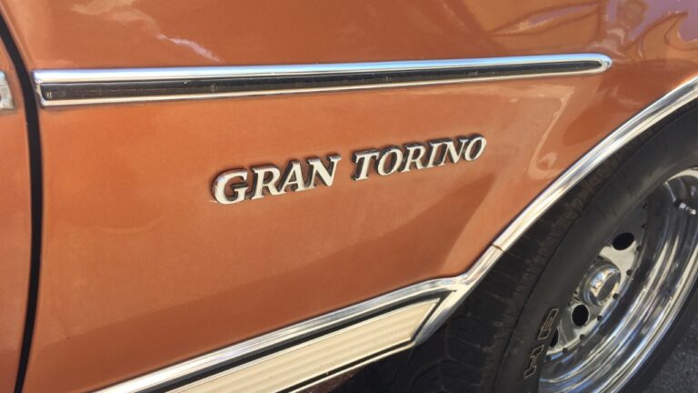 Text emblem 'GRAN TORINO' on the side of a bronze-orange vehicle from the 1970s.