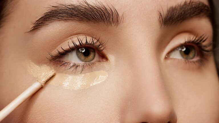 A close-up of a woman applying the finishing touches to her makeup look.