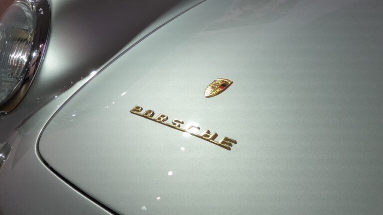 Close-up of the emblem on the hood of a Silver 1956 Porsche 550 Spyder at Porsche Ikonen Seoul.