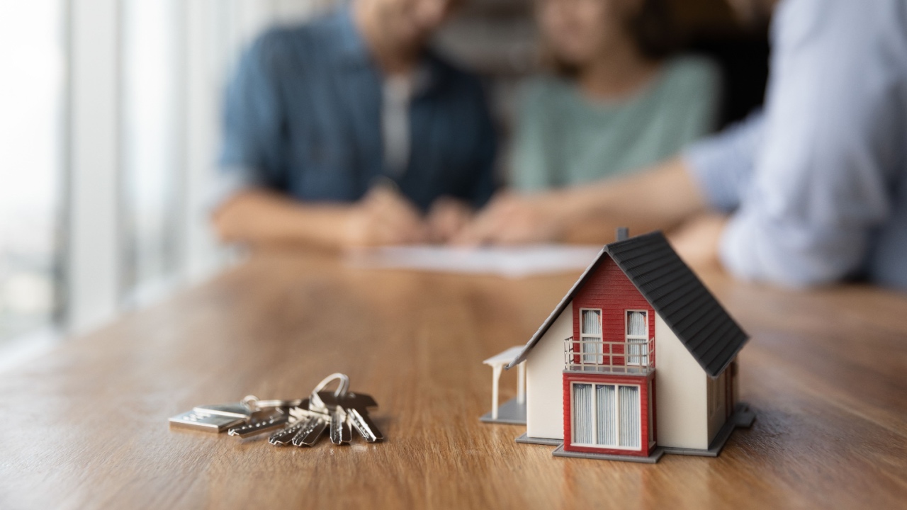 Model tiny home on table with keys.
