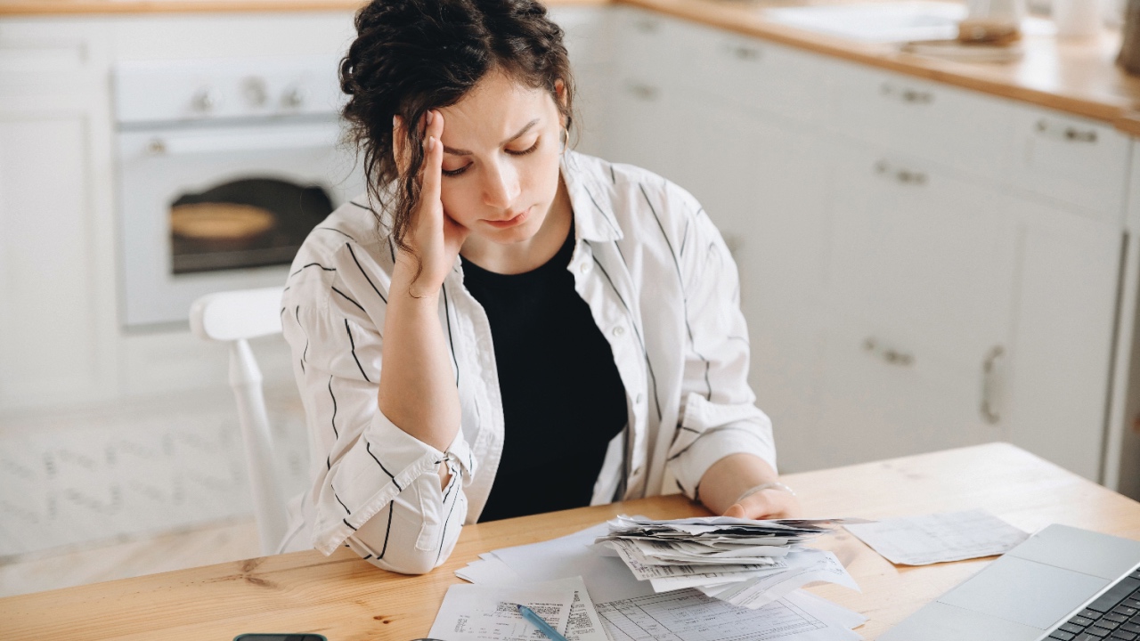 Stressed woman looking at utility bills. 