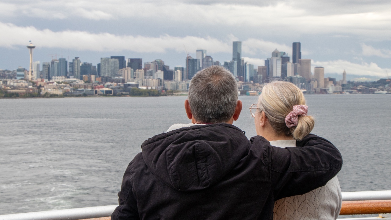 Couple gazing at Seattle skyline from cruise ship on Puget Sound - Seattle, Washington, USA