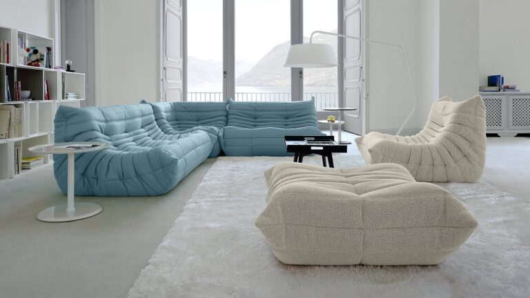 A living room with minimal decor including blue and cream colored couches.