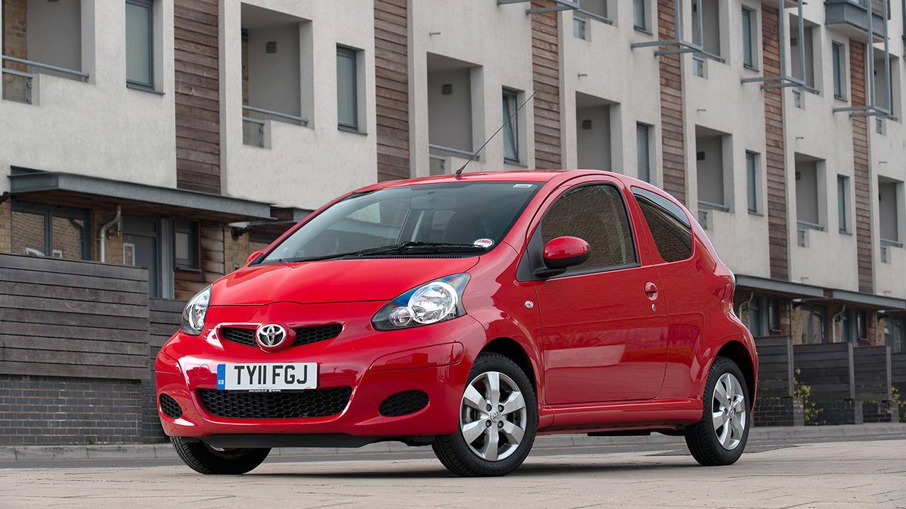 Toyota Aygo, front 3/4 view, red exterior, first generation, urban area