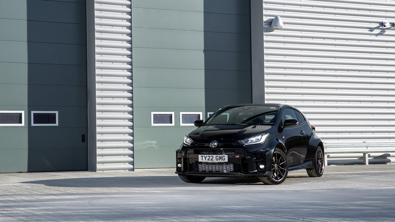 Toyota GR Yaris, front 3/4 view, black, static, garage doors