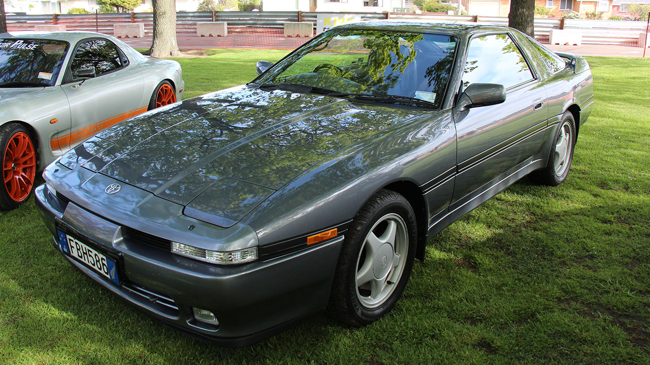 Toyota Supra A70, front 3/4 view, field, gray exterior, five spoke wheels