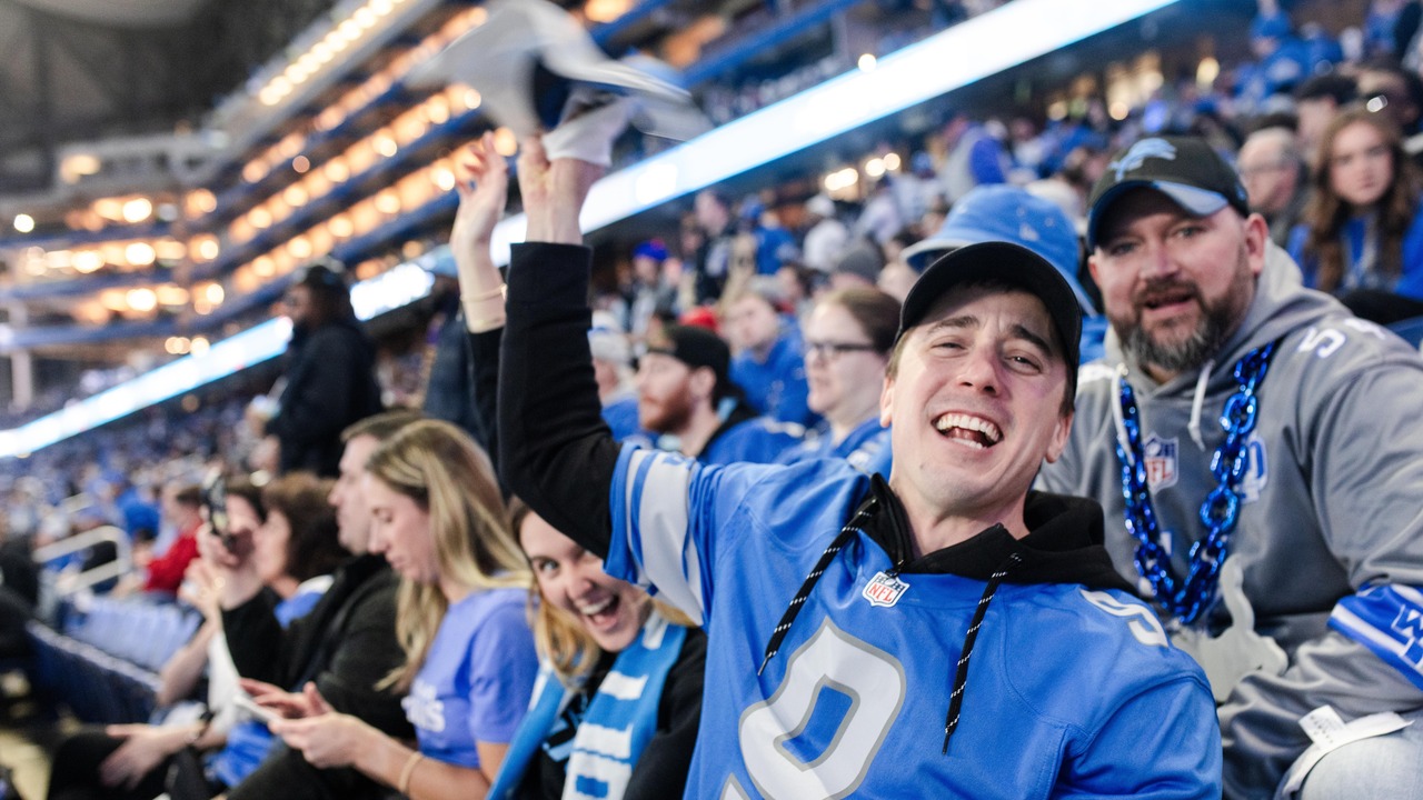 A group of Lions fans, cheering at a game in Detroit.