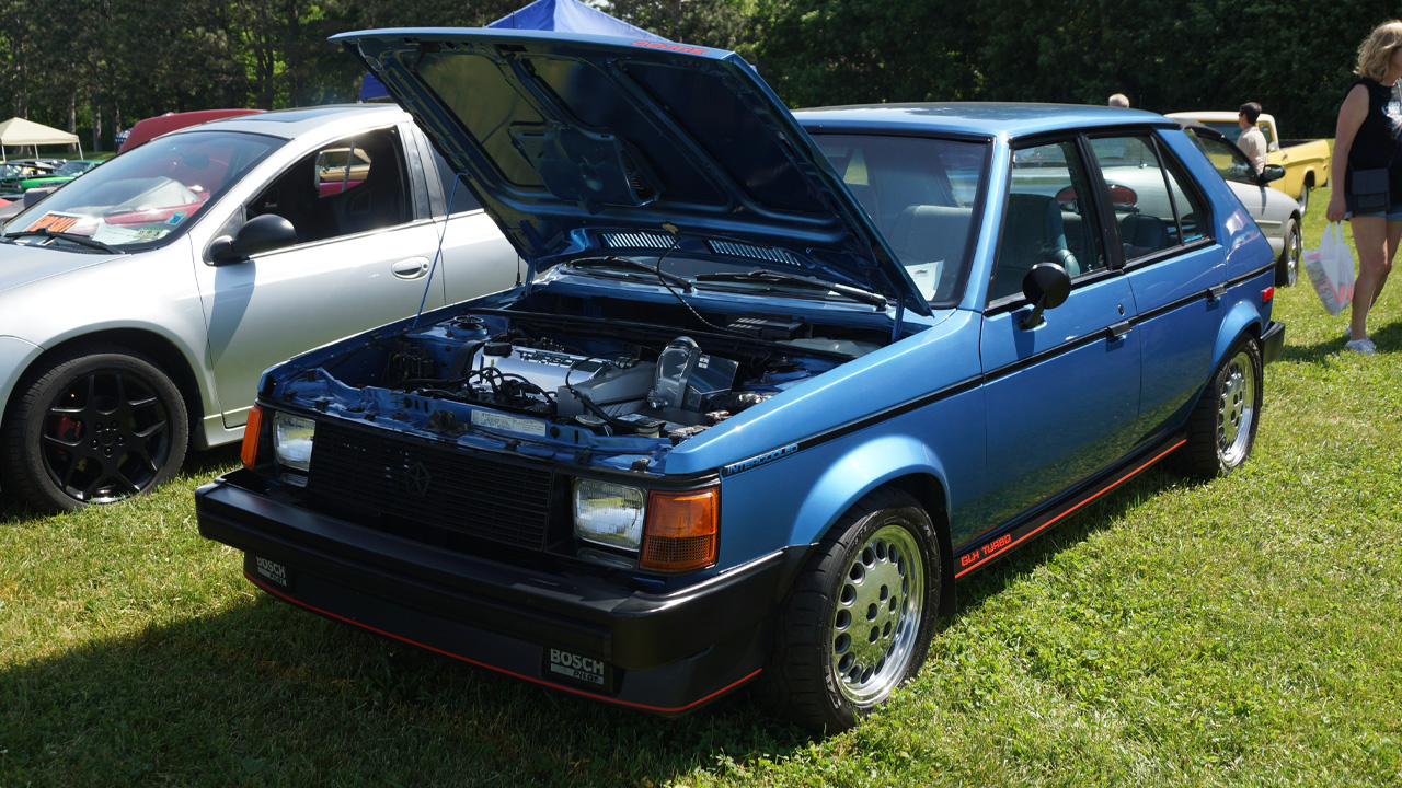 Dodge Omni GLH, front 3/4 view, blue exterior, open air car show