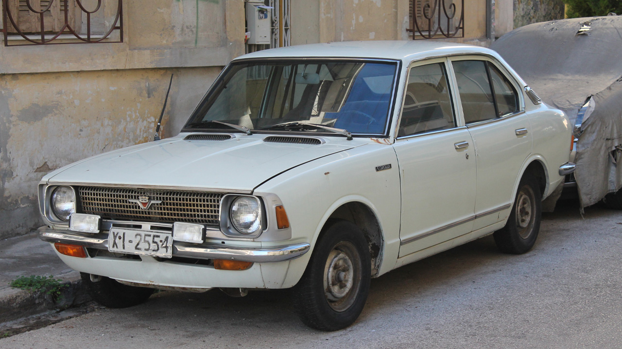 Toyota Corolla E20 sedan, front 3/4 view, white exterior, street parked