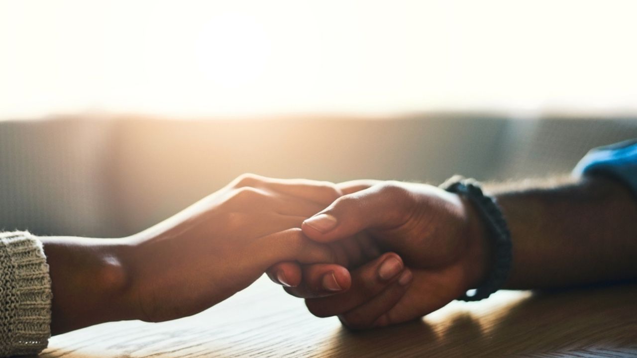 Empathy, love and mental health with friends holding hands for safety, security or trust in home closeup. Depression, love or praying and people in pain from grief or loss with compassion and hope